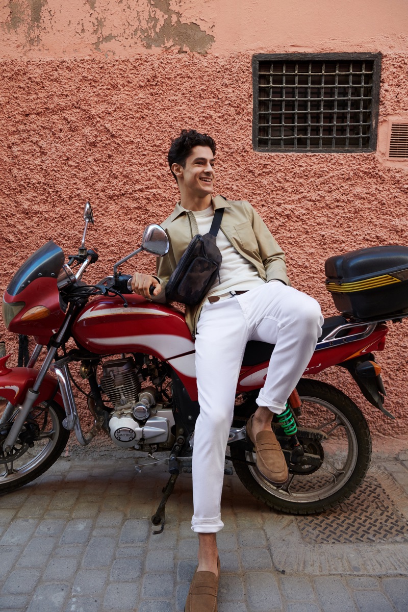 All smiles, Cyrus Amini wears Banana Republic's Core Temp coach's jacket $149, chinos $98, suede loafers $148, and a camouflage print belt bag $59.50.
