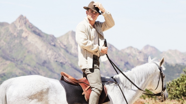 Riding a horse, Dacre Montgomery sports an Our Legacy linen jacket, Billy tank, Man 1924 trousers, and Golden Goose sneakers.