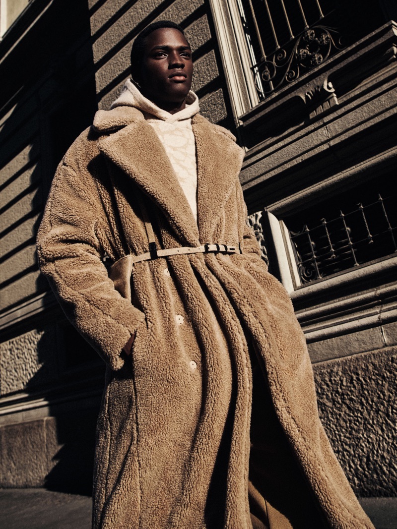 Daniel Morel dons a chic shearling coat for Emporio Armani's fall-winter 2019 men's campaign.