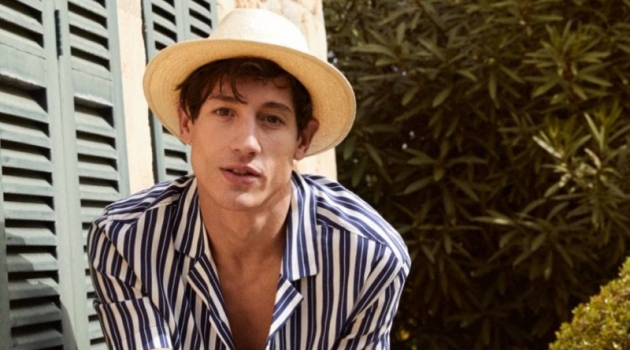 Nicolas Ripoll Enjoys Summer Moments in H&M Resort Shirts Posing on a bike, Nicolas Ripoll wears a blue and white striped resort shirt $12.99 from H&M.