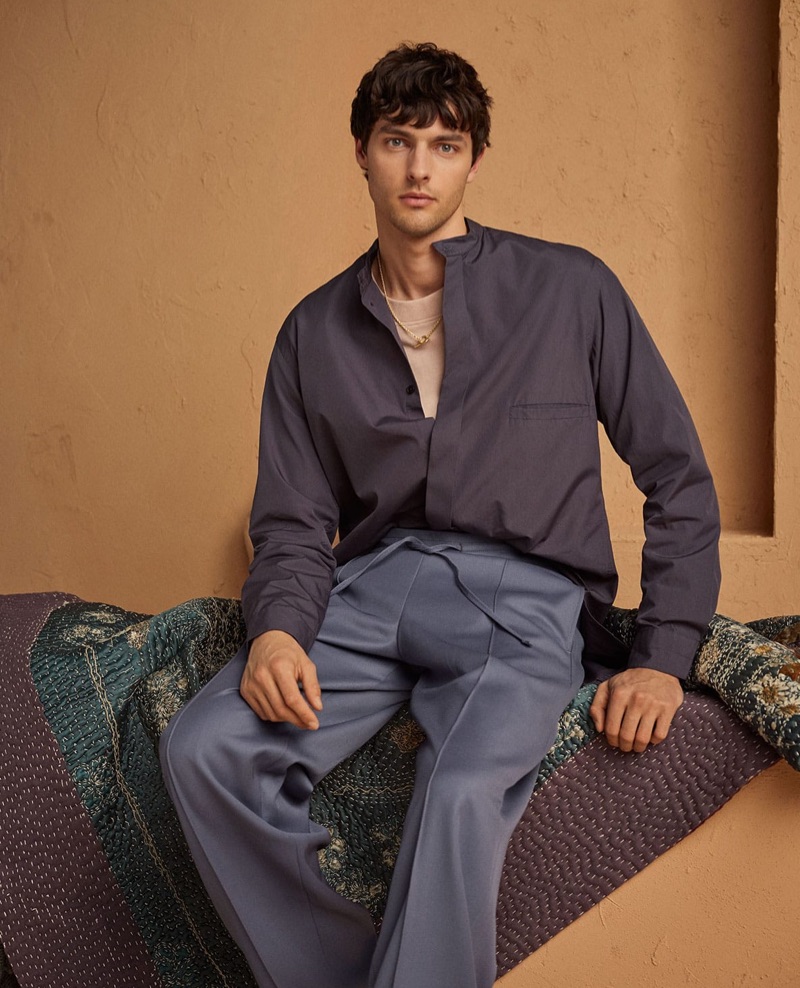 A chic vision, Hannes Gobeyn wears a Lemaire shirt and sweater with Dunhill trousers. He also dons an All Blues necklace.