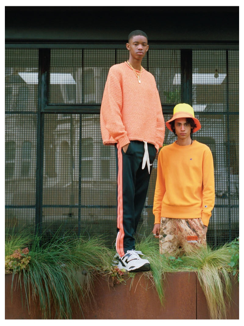 From left, Montell wears ACNE STUDIOS sweater £430; PALM ANGELS track pants £285; VERSACE necklace £370; HERON PRESTON padlock necklace £245; DSQUARED2 trainers from a selection; Benjamin wears CHAMPION sweatshirt £76.95; HERON PRESTON trousers £310; DSQUARED2 hat £215; GIVENCHY ring £240