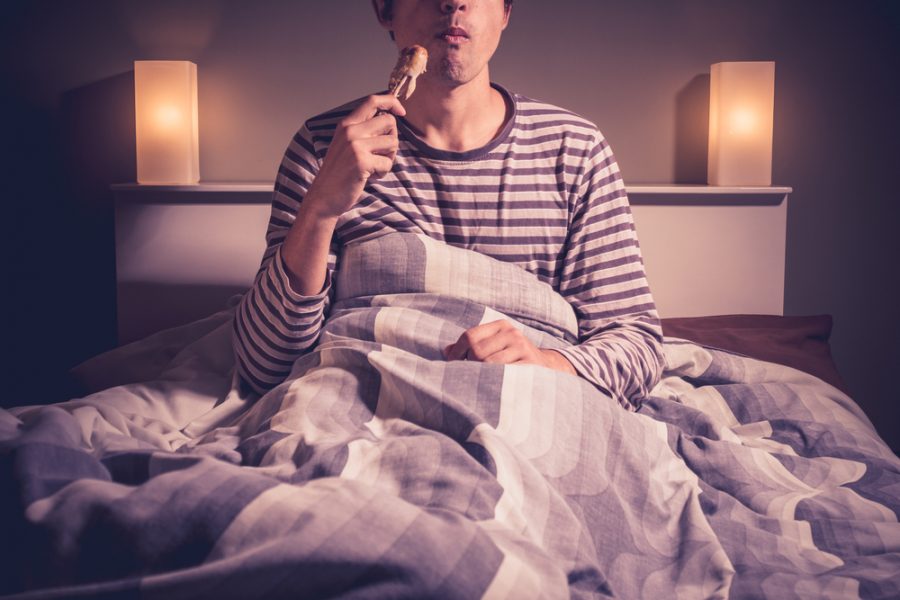Man Eating in Bed