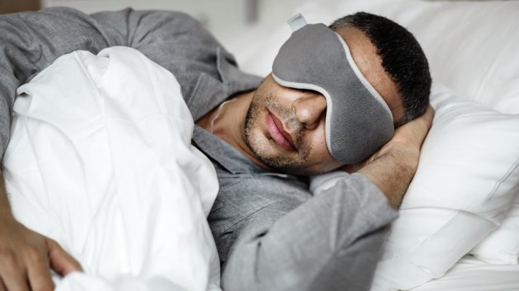 Man Laying in Bed with Sleeping Mask