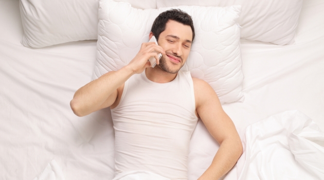 Eliminate Bed Bugs & Get the Perfect Mattress Man in Bed Talking on Phone
