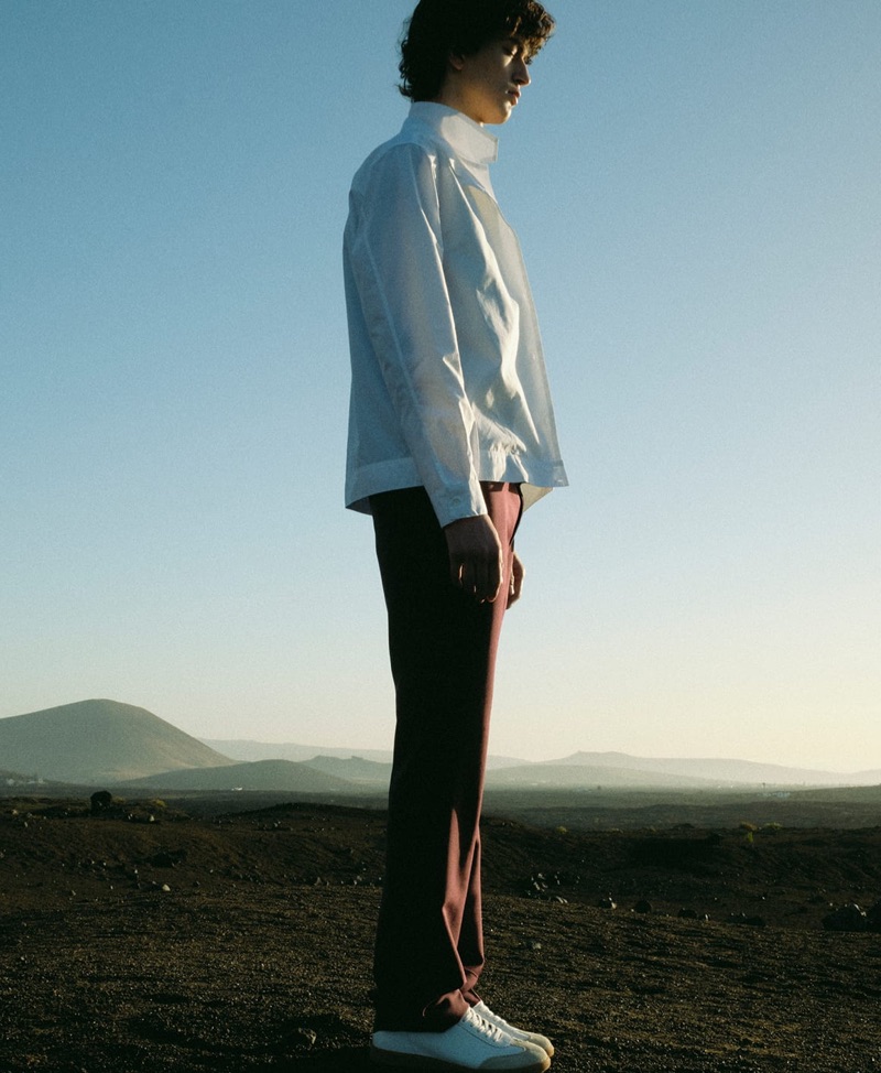 Delivering a side profile, Gena Malinin wears a Deveaux shirt, Prada trousers, and Isabel Marant sneakers. 