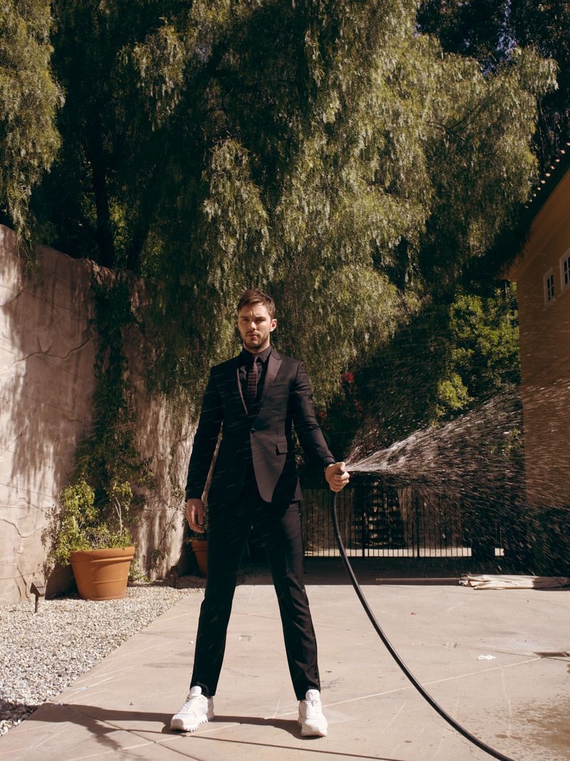 An elegant vision, Nicholas Hoult dons a Berluti shirt and tuxedo with a Celine tie and Louis Vuitton sneakers.