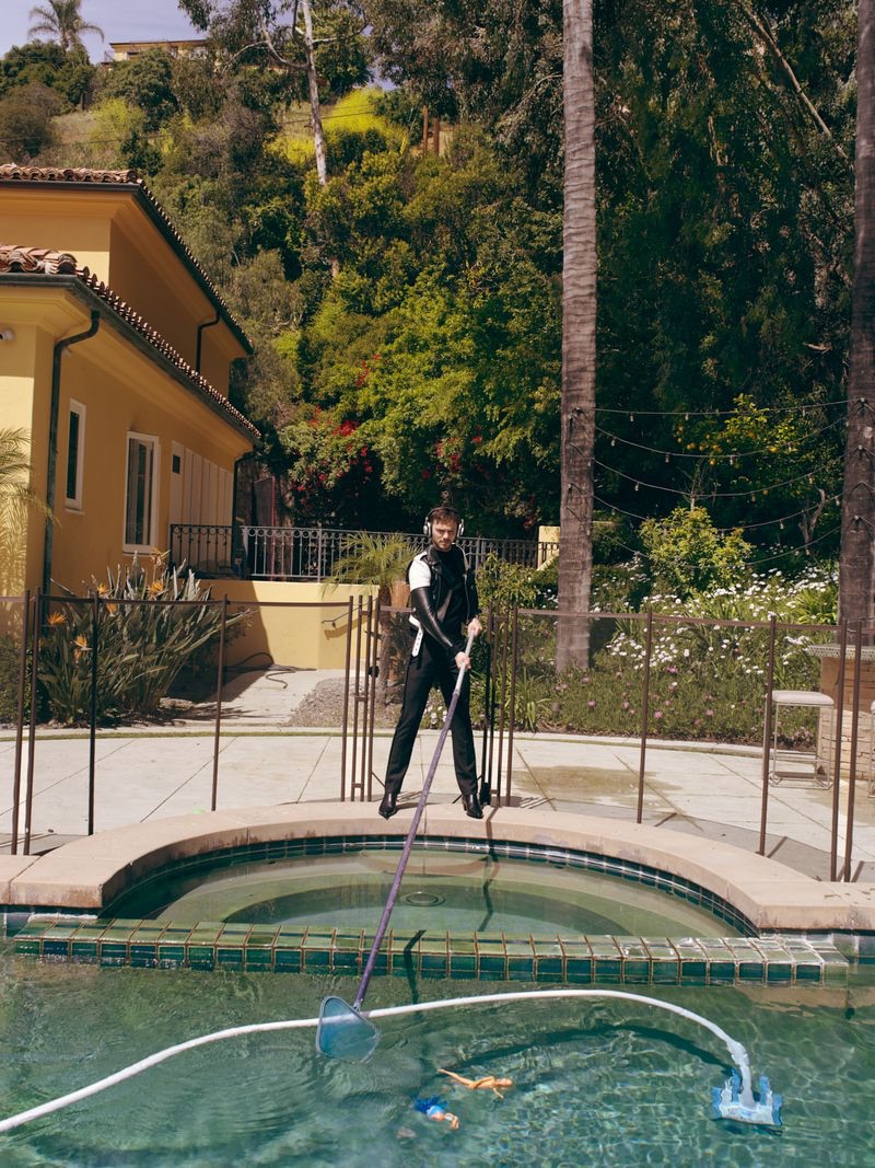 Tending to the pool, Nicholas Hoult wears Celine.