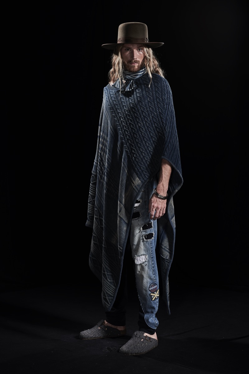 Aiden Andrews wears a cable-knit poncho and patched jeans from Paul & Shark by Greg Lauren.