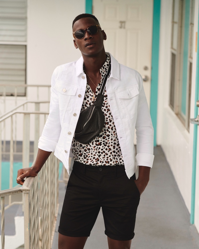 David Agbodji sports a white jean jacket with a leopard print shirt and black shorts from River Island.