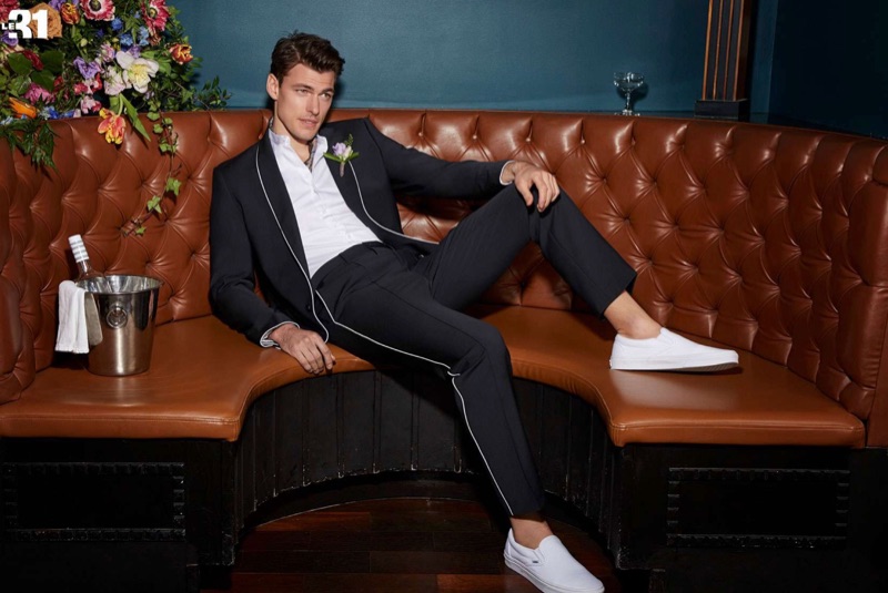 Making a clean statement, Filip Wolfe wears a piped suit jacket and pants with an officer collar shirt by LE 31. White Vans classic slip-ons complete his look.