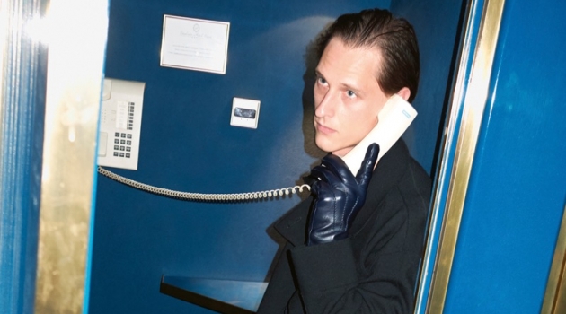 Taking a phone call, Rogier Bosschaart wears a Giorgio Armani coat, sweater, and pants with Gucci accessories.
