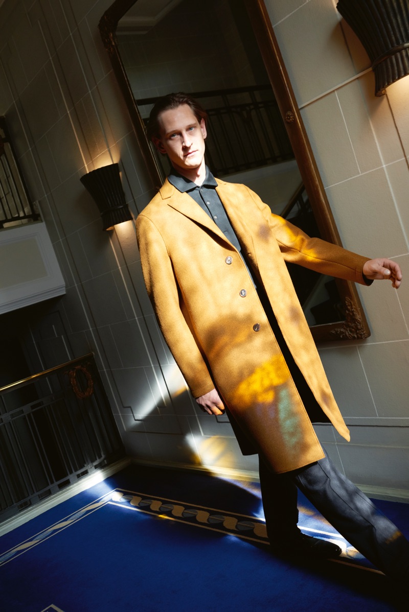 On the move, Rogier Bosschaart dons a Harris Wharf coat with a polo and pants by Giorgio Armani.