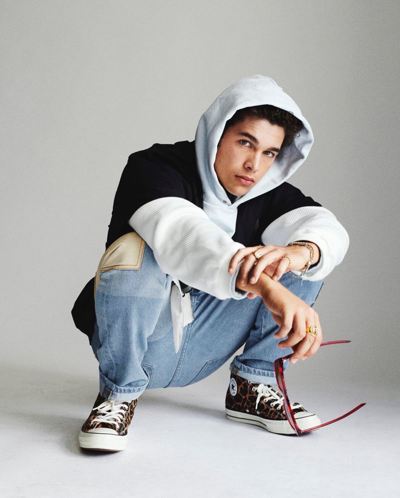 Singer Austin Mahone sports a MENACE hoodie and jeans with Converse sneakers.