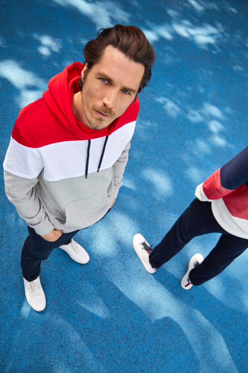 Going sporty, Guillaume Macé rocks a block-striped hoodie with skinny jeans from Esprit.