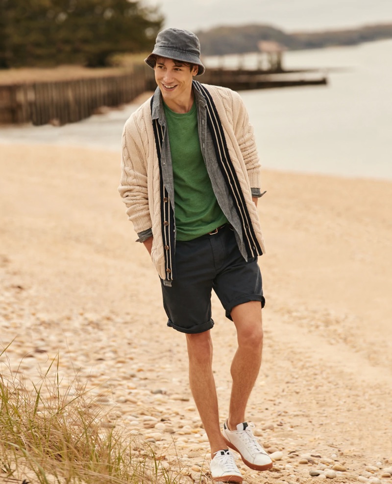 All smiles, Nicolas Ripoll wears a J.Crew cable-knit cardigan $125, chambray shirt $79.50, t-shirt $19.50, 10.5" chino shorts $65, and a bucket hat $39.50.