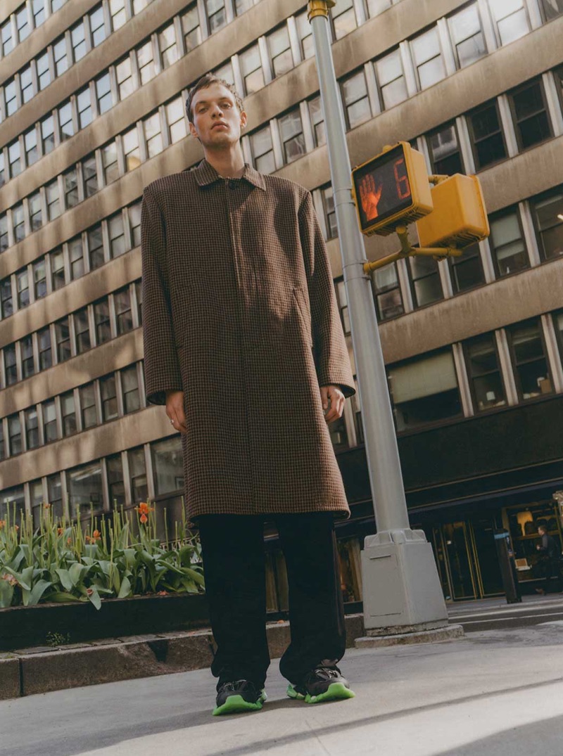 Photographed in New York, Rocky Harwood dons a coat, trousers, and sneakers from Balenciaga.