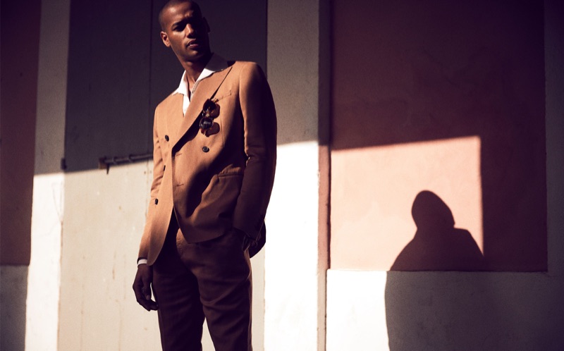 Embracing brown, Sacha M'Baye is sharp in a double-breasted suit by Reiss.