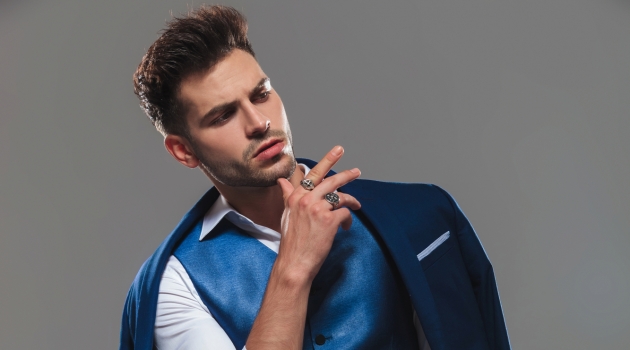 Why Rings Are the Next Must-Have Accessories for Men Stylish Man Posing Wearing Suit Vest and Rings