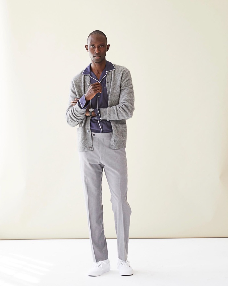 Model Armando Cabral sports a Todd Snyder long-sleeve camp collar tipped navy shirt $228 with a cardigan and trousers.