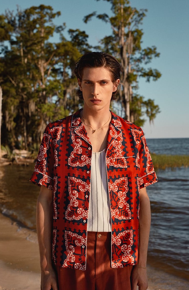 Standing out in red, Edoardo Sebastianelli rocks a Valentino shirt, Marrakshi Life tank, De Bonne Facture shorts, and a Shaun Leane necklace.