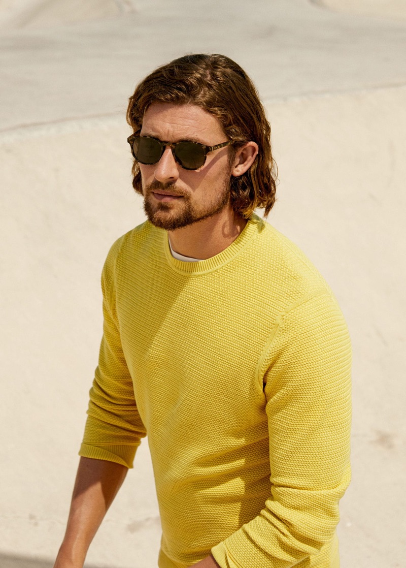 Embracing a pop of color, Wouter Peelen dons a yellow sweater from Mango Man.
