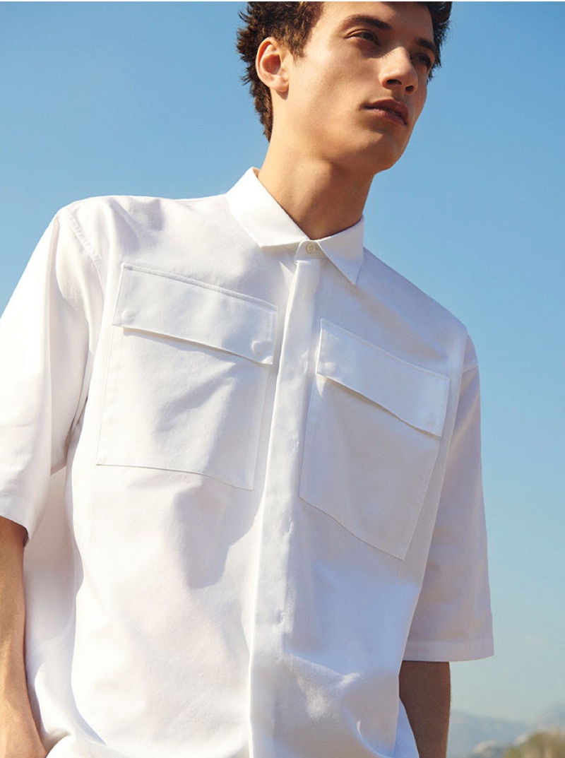 A summer vision, Serge Rigvava sports a white pocketed shirt from YOOX.