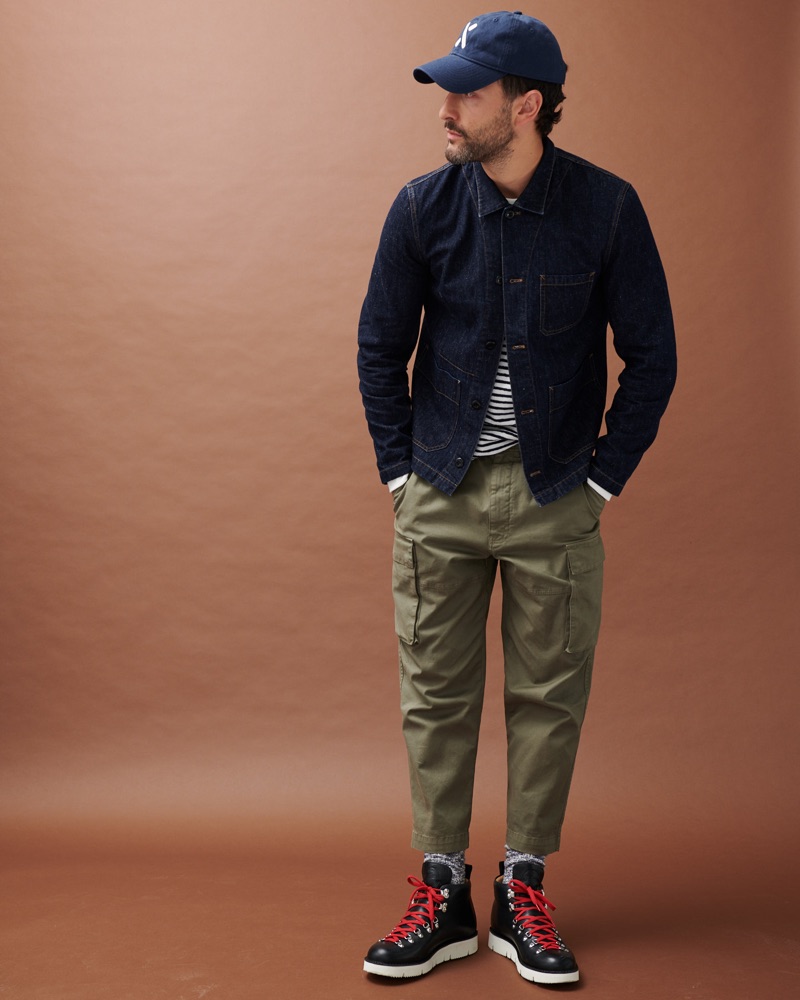 Going casual, Noah Mills models a denim jacket with a striped top and cargo pants by Alex Mill.