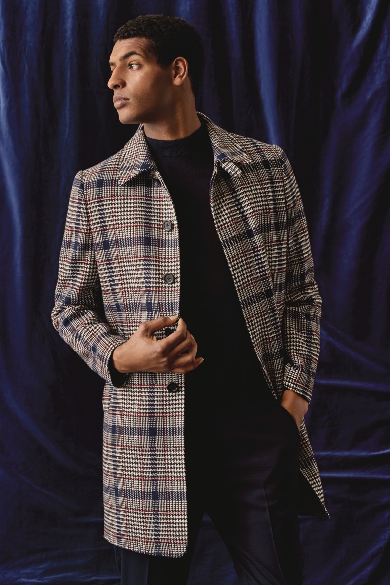 Sporting a checked coat, Tidiou M'Baye wears Burton.