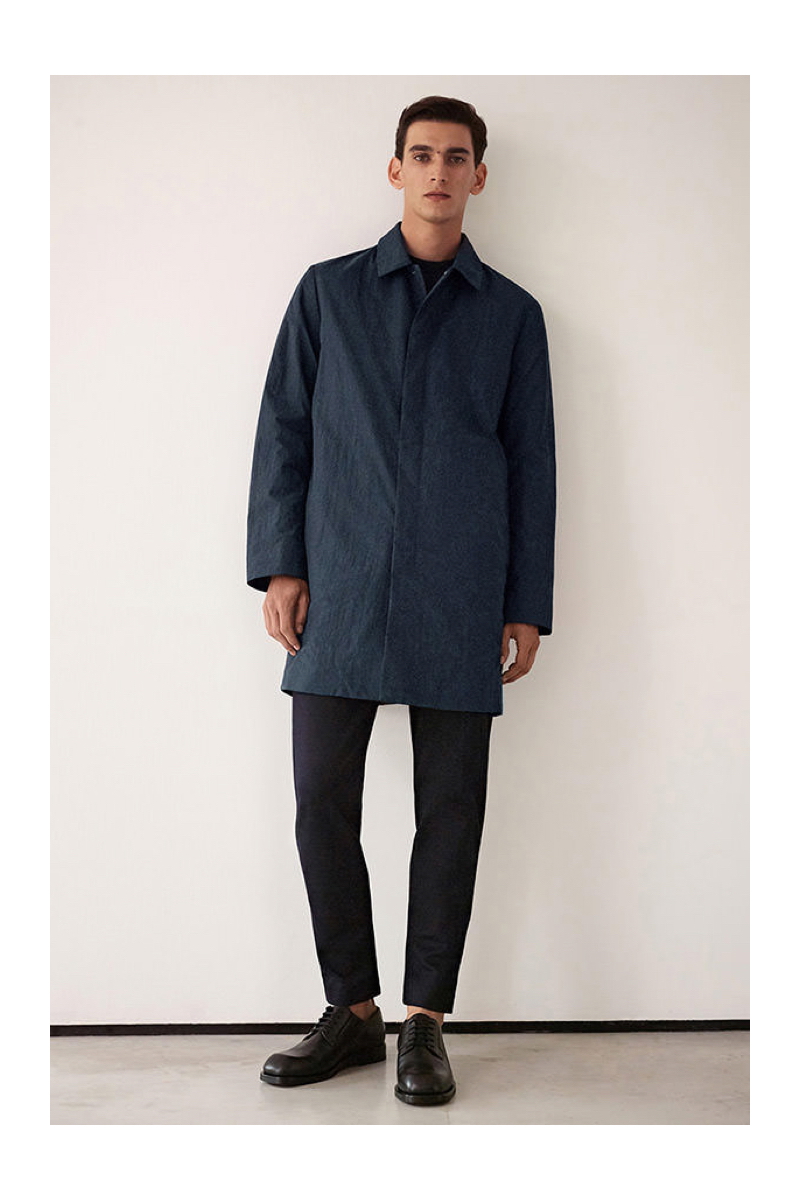 Model Thibaud Charon sports a mac coat with trousers by COS.