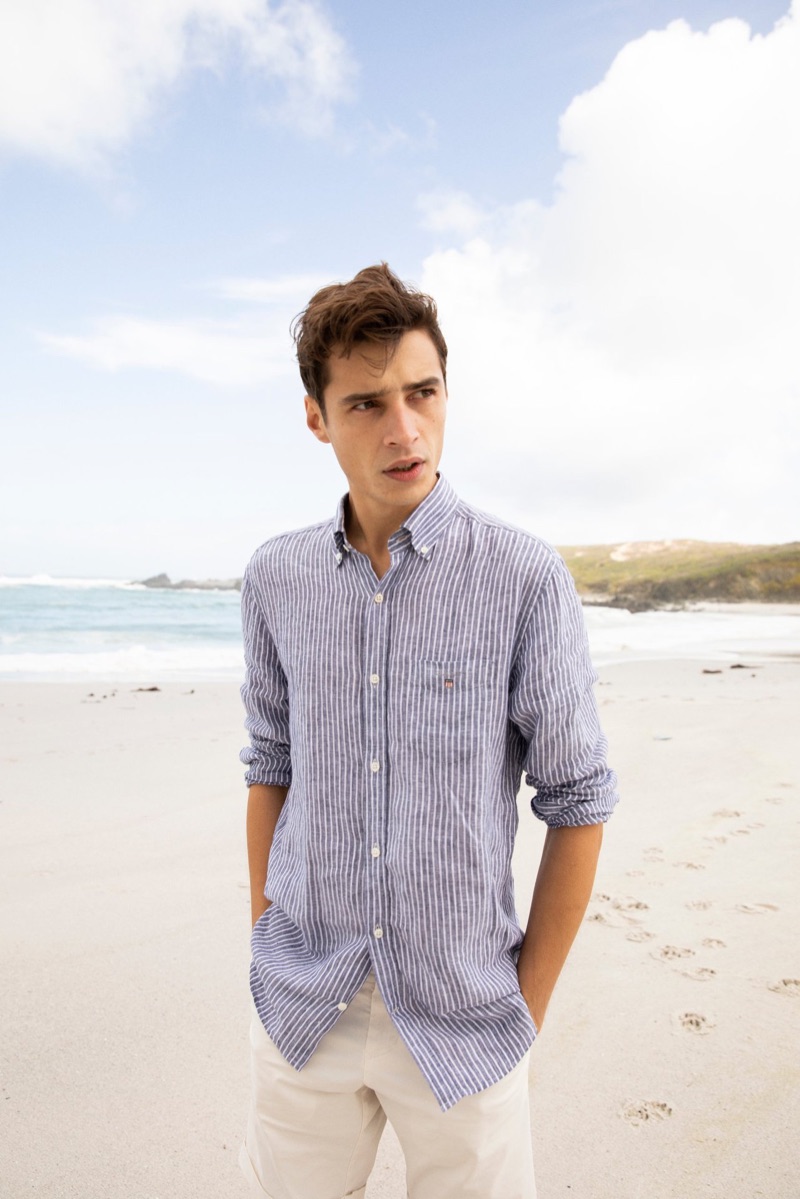 Enjoying a day at the beach, Adrien Sahores dons a striped linen shirt from GANT.