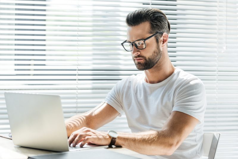 Man on Laptop Wearing Glasses