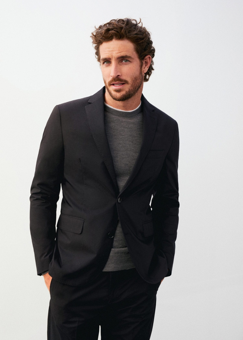 Dressed to impress, Justin Joslin models a two-button suit with a grey sweater by Mango.