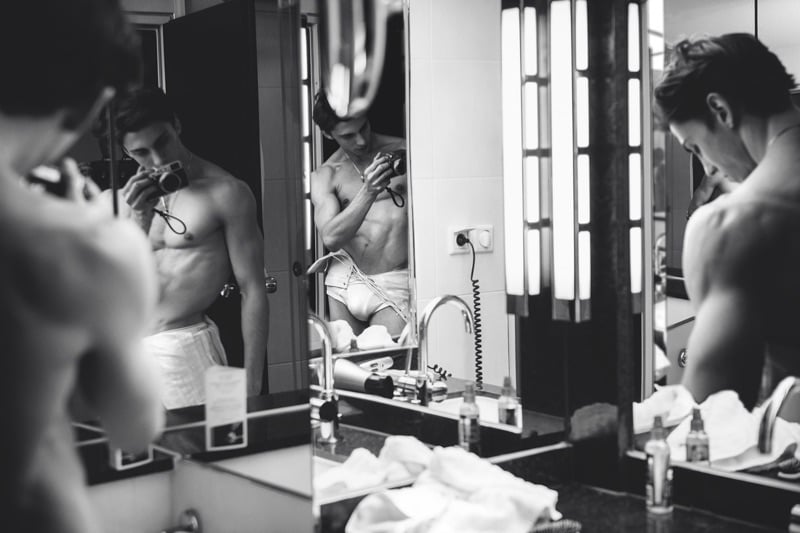 Appearing in a black and white series, Matteo Miccini poses in front of the mirror.