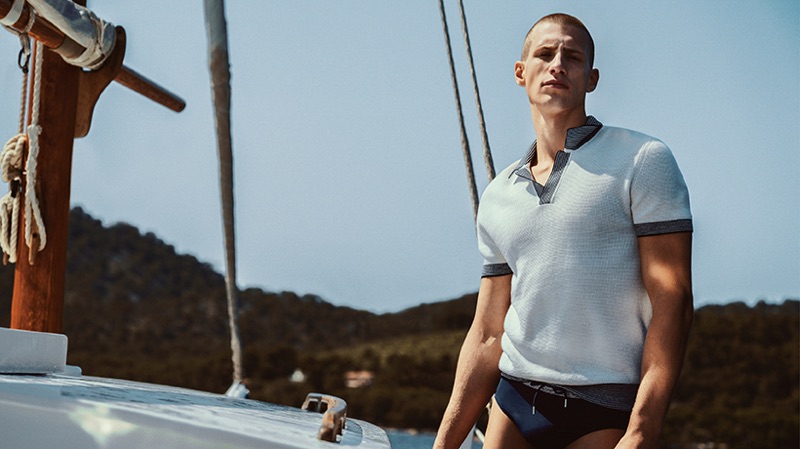 Taking to a sailboat, Augusta Alexander wears a swimsuit and polo from Orlebar Brown.