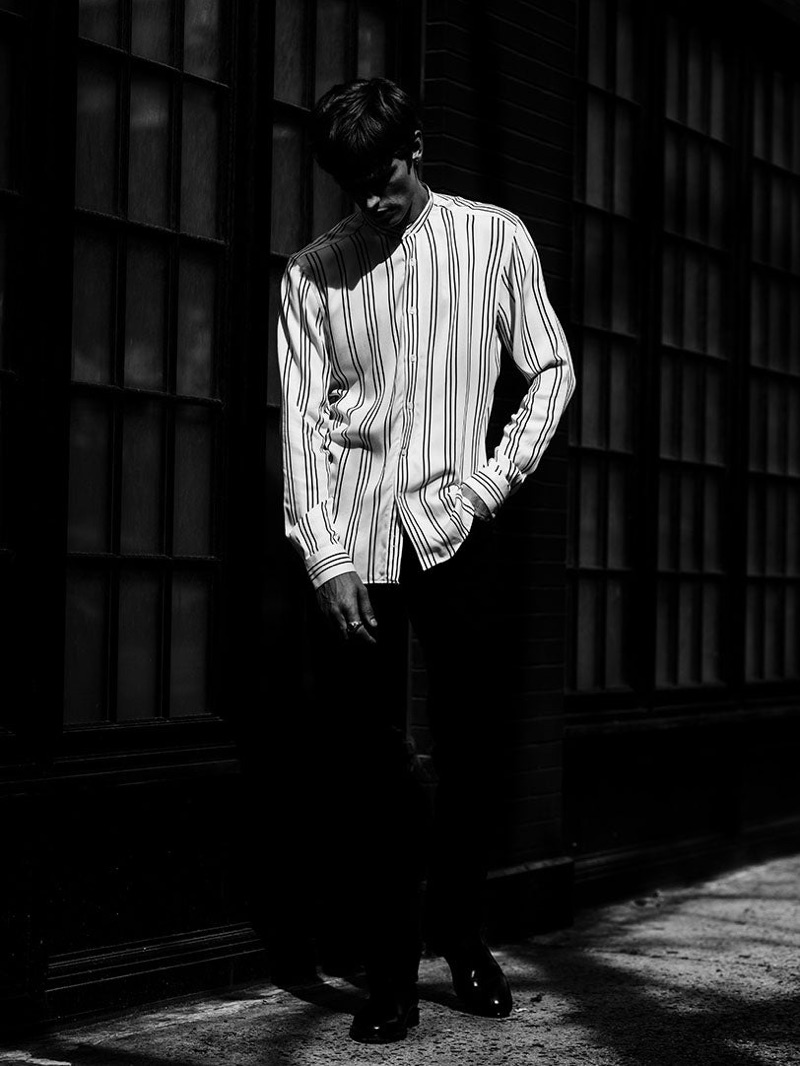 Posing for a moody image, Janis Ancens wears a striped grandad collar shirt by Reiss.