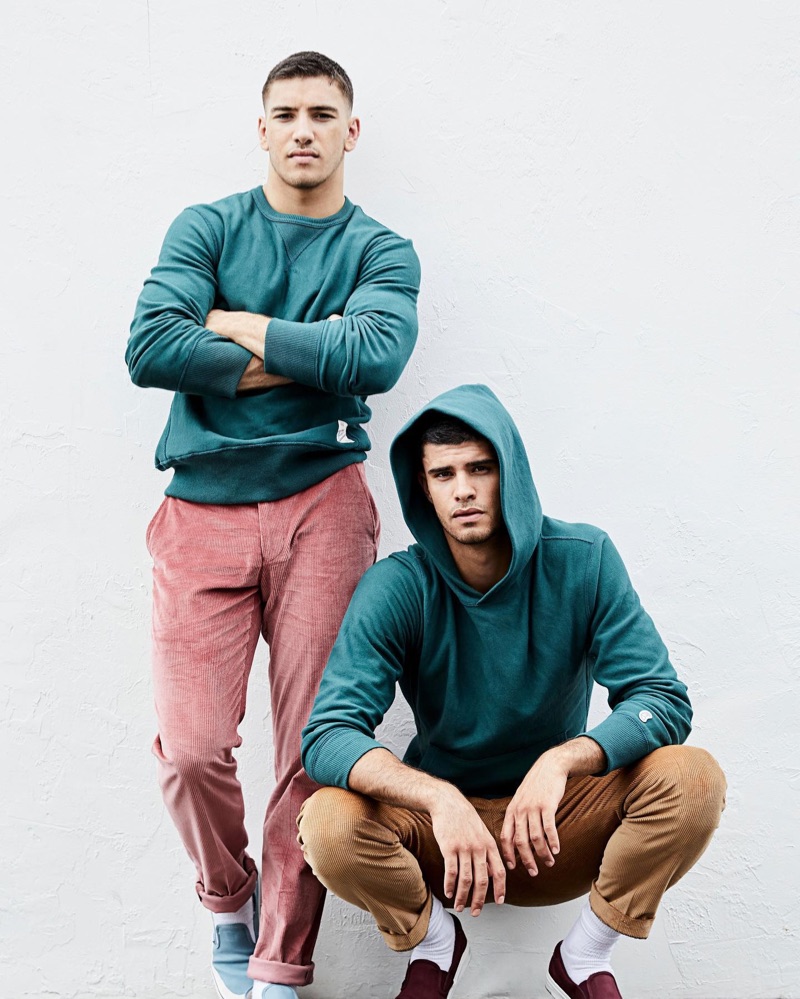 Pictured left, Ismail sports a Todd Snyder + Champion green pullover $148 with Todd Snyder Sutton corduroy trousers $228 in mauve. Meanwhile, Jaad dons a Todd Snyder + Champion green hoodie $138 with corduroy pants.