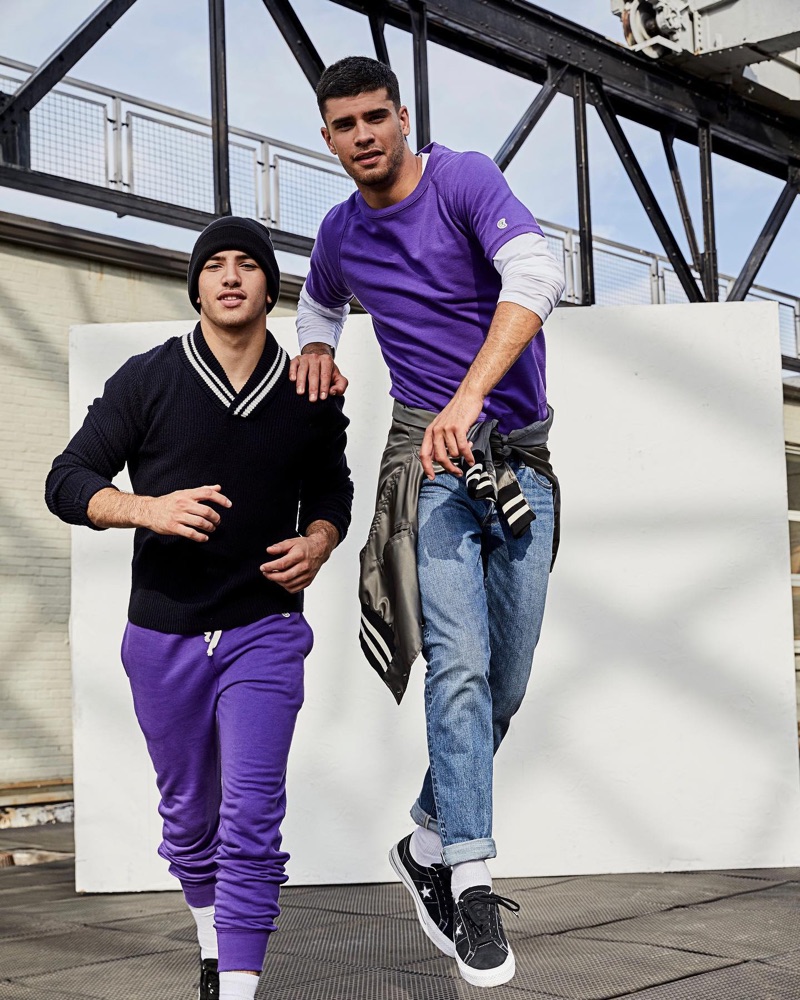Sporting a navy Todd Snyder tipped shawl collar sweater $228, Ismail also wears royal purple joggers $118. Right: Jaad dons a royal purple Todd Snyder + Champion jersey tee $50 with Todd Snyder slim-fit Japanese stretch selvedge jeans $198.