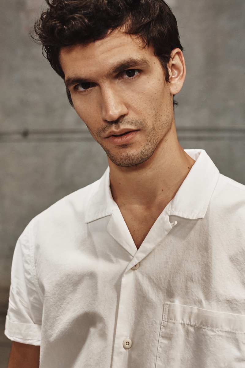 Model Alfredo Nemer rocks a white Cuban-collared shirt from AG Jeans' spring-summer 2020 collection.