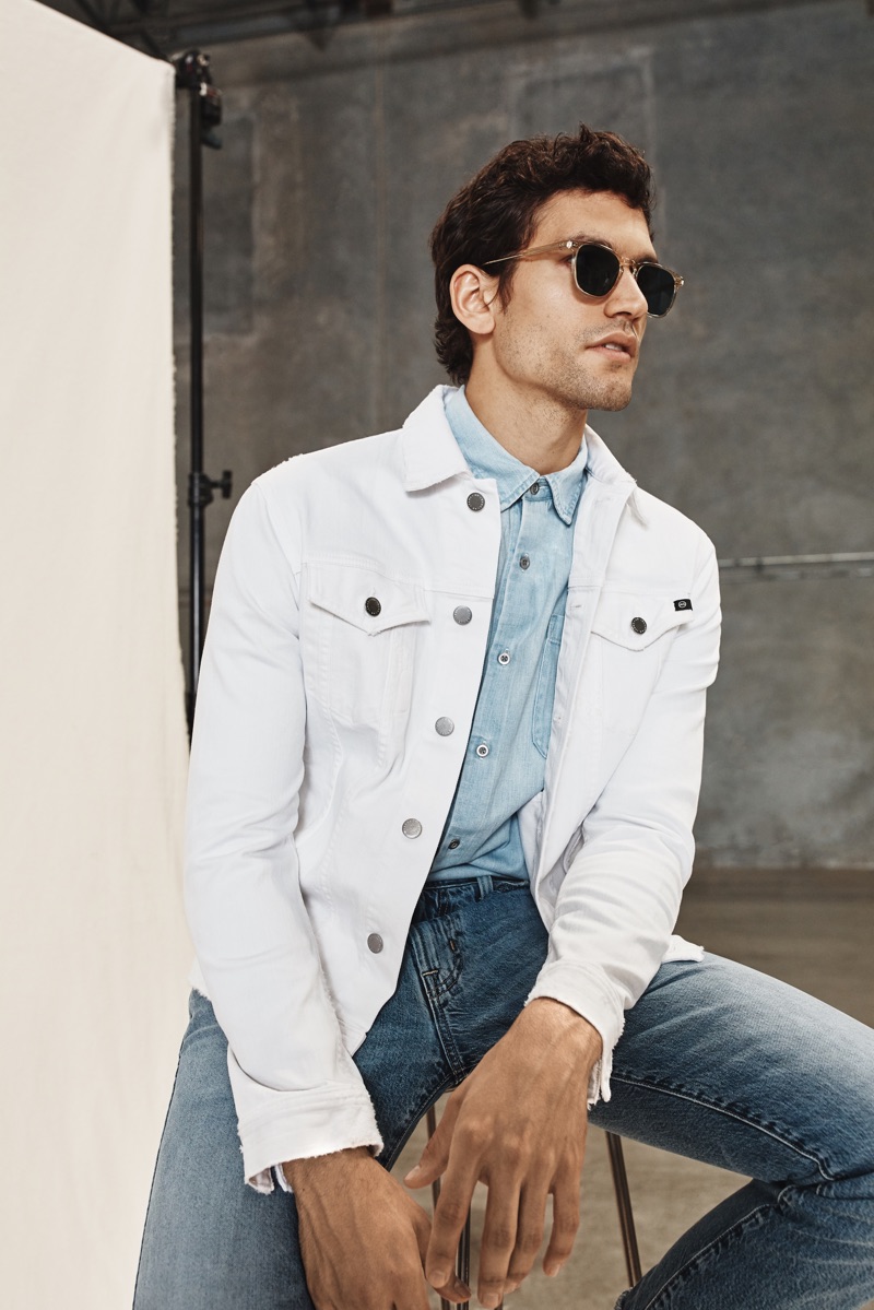 Sporting a white denim jacket and other pieces, Alfredo Nemer wears a look from AG Jeans' spring-summer 2020 collection.