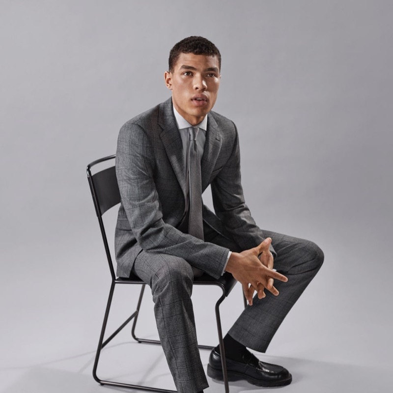 Front and center, Louis Griffiths sports a grey suit by Calvin Klein.