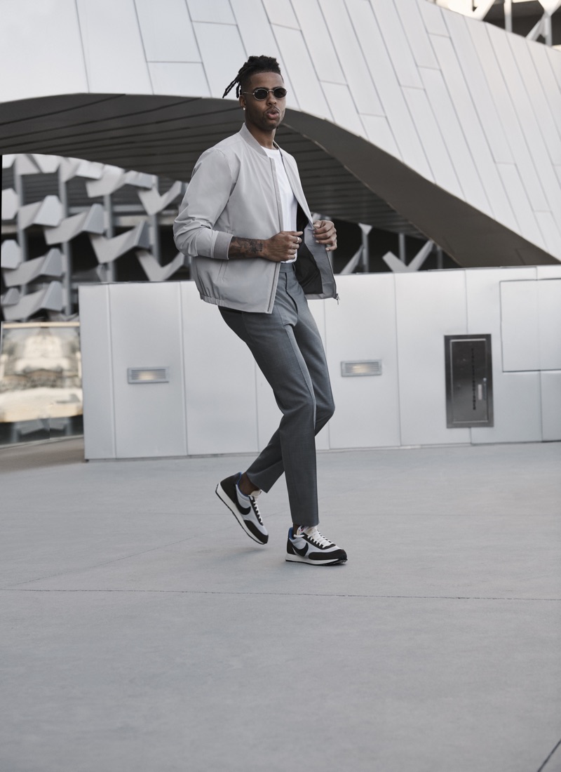 Going sporty but smart, D'Angelo Russell wears a Theory bomber jacket with an ATM t-shirt, Canali dress pants, and Ray-Ban sunglasses.