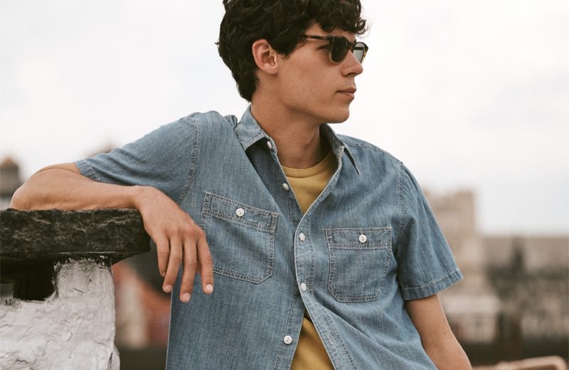 Tyler Sports Key Ways to Wear Denim for East Dane Going simple, Tyler Blue Golden rocks a Madewell chambray shirt and t-shirt with Oliver Peoples Finley Esquire sunglasses.