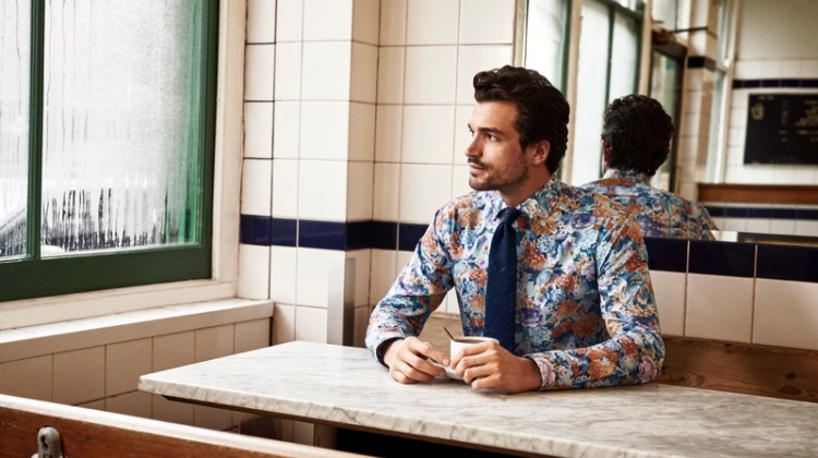 Enjoying a cup of coffee, Paul Kelly models a patterned shirt from Eton's holiday 2019 collection.