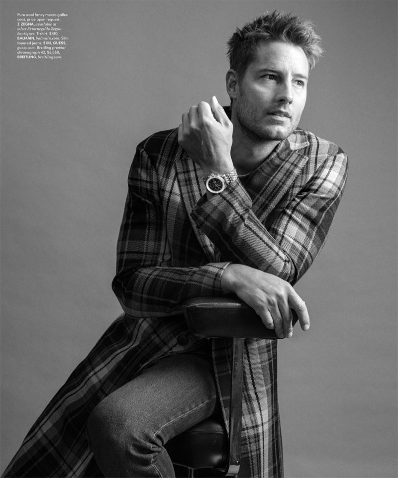 Taking to the studio for DuJour, Justin Hartley wears a checked Z Zegna coat with a Balmain t-shirt, GUESS jeans, and a Breitling watch.