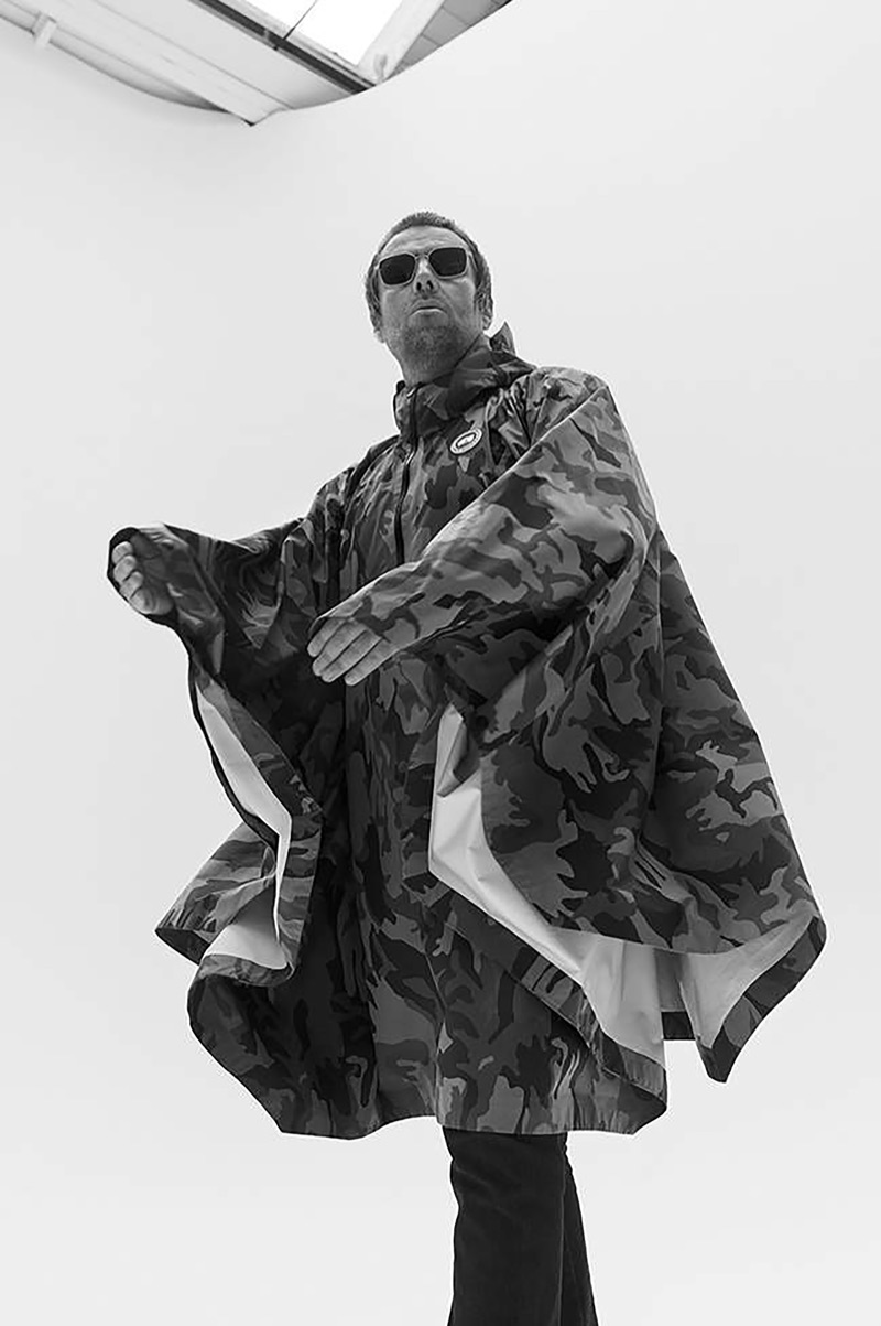 Donning a Canada Goose camouflage print poncho, Liam Gallagher also wears Acne Studios jeans and Cubitts sunglasses.