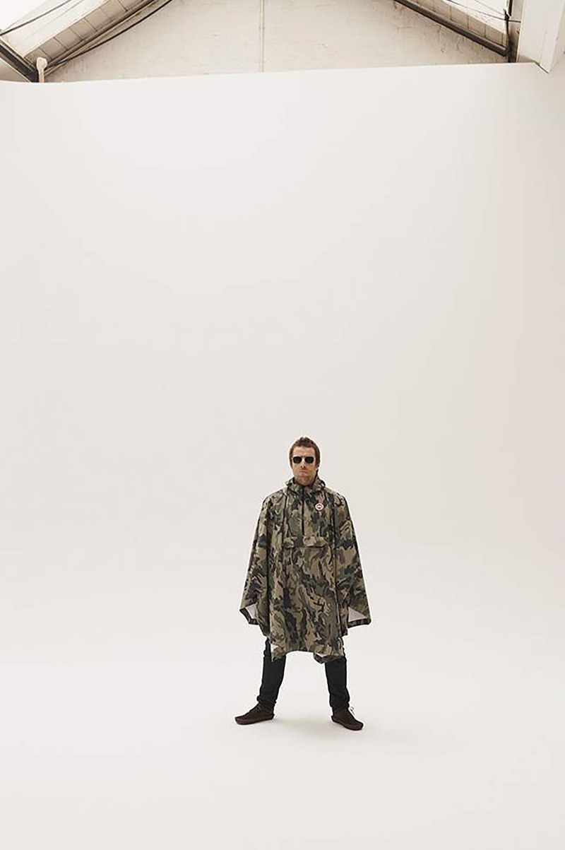 Starring in a photo shoot, Liam Gallagher wears a Canada Goose camouflage-print poncho, Acne Studios jeans, Cubitts sunglasses, and Visvim suede boots.