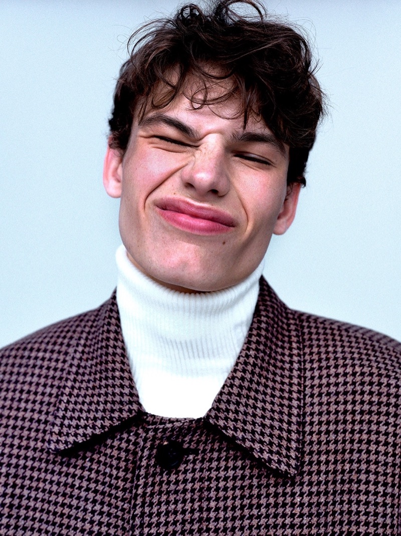 Pulling a quirky face, Louis Gockenjan wears a Balenciaga houndstooth coat $2,950 with a Jil Sander turtleneck $170.