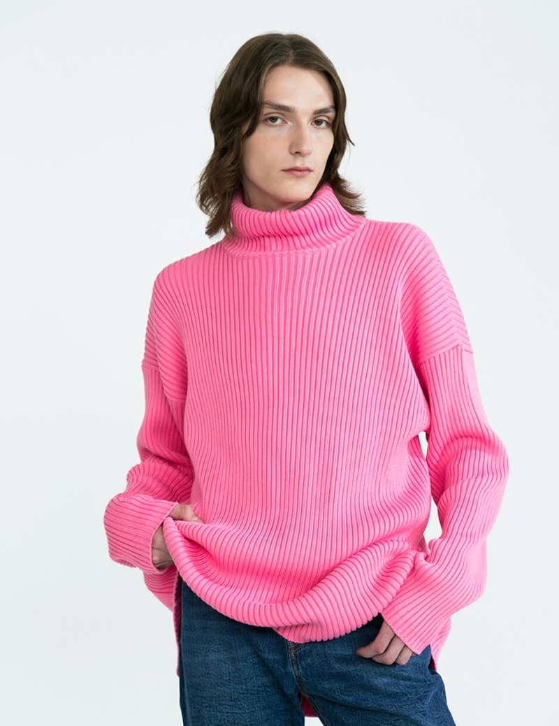 Alex Rychkov sports a pink ribbed Balenciaga turtleneck sweater $1290 and Versace jeans $525.