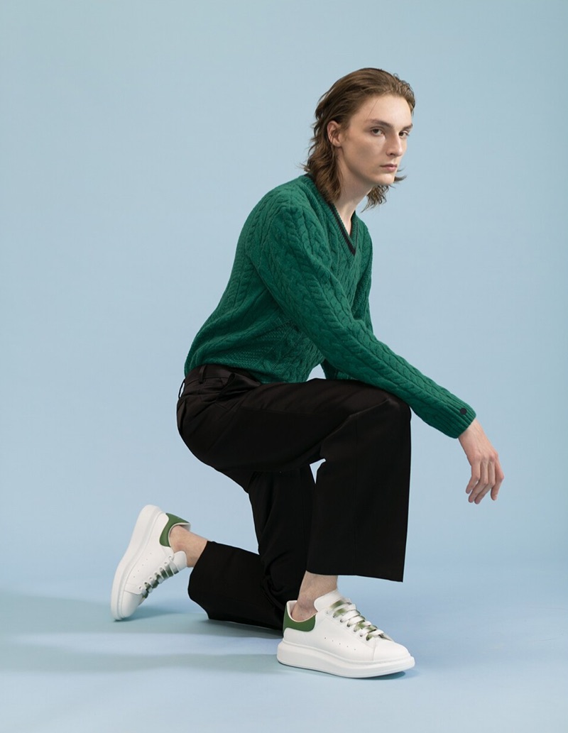 A smart vision, Alex Rychkov rocks a green Lanvin v-neck sweater $1,390, MSGM chino pants $350, and Alexander McQueen sneakers $490.